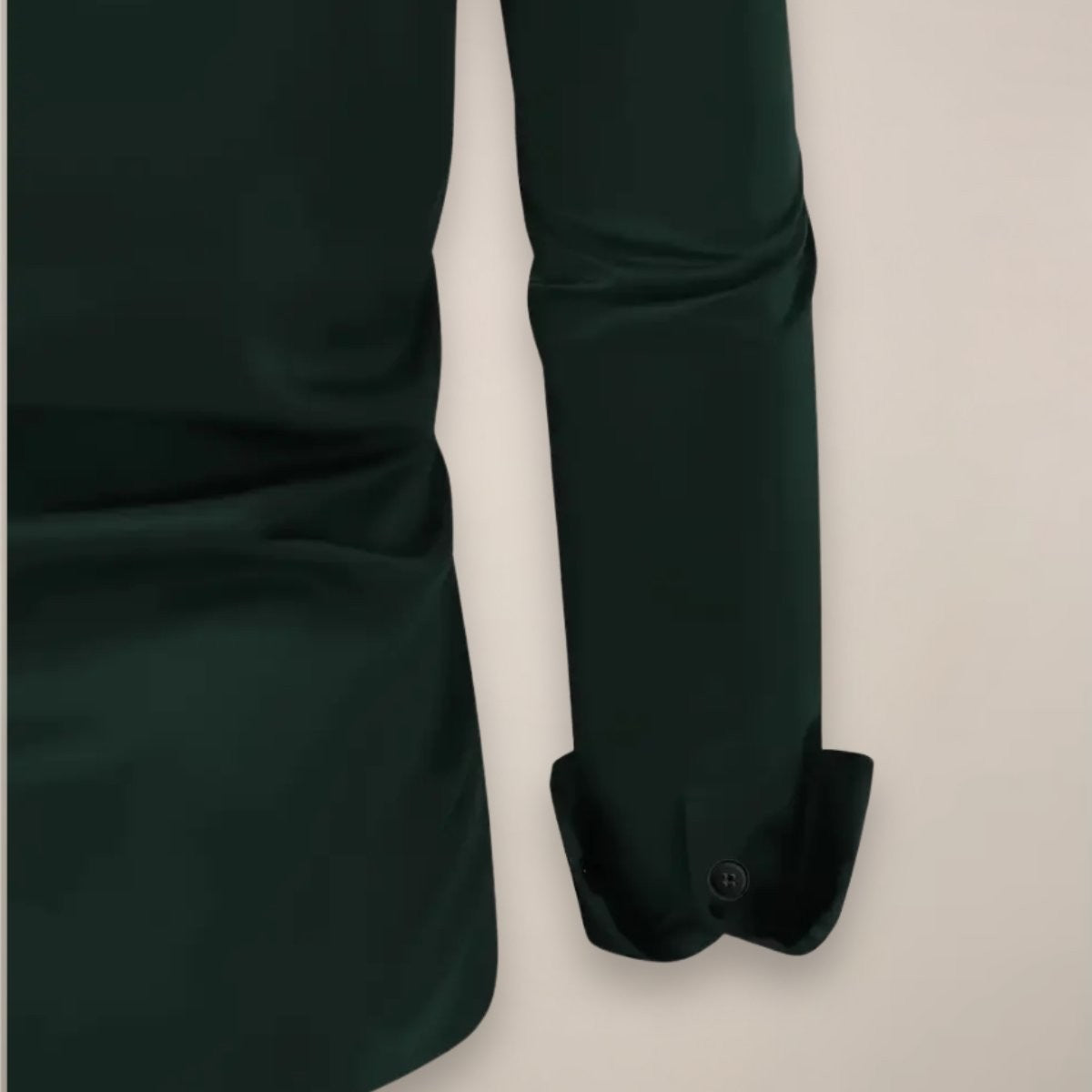 Close-up of dark green shirt cuff and sleeve with button fastening