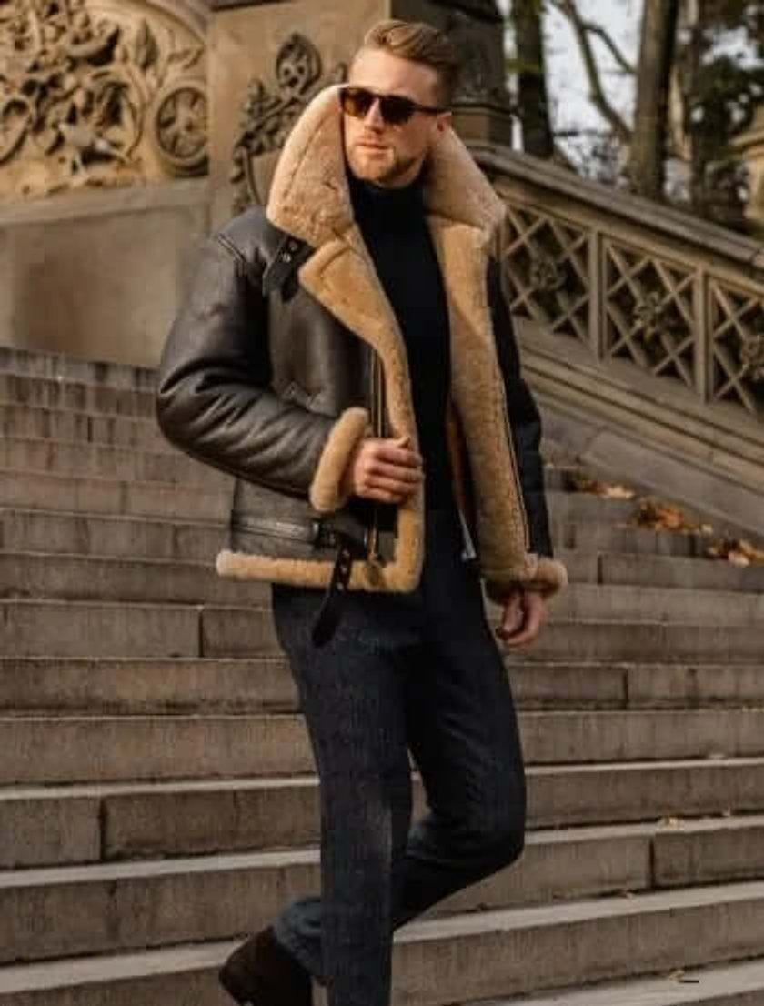 Man in brown shearling flying jacket descending stone steps in tan fur collar