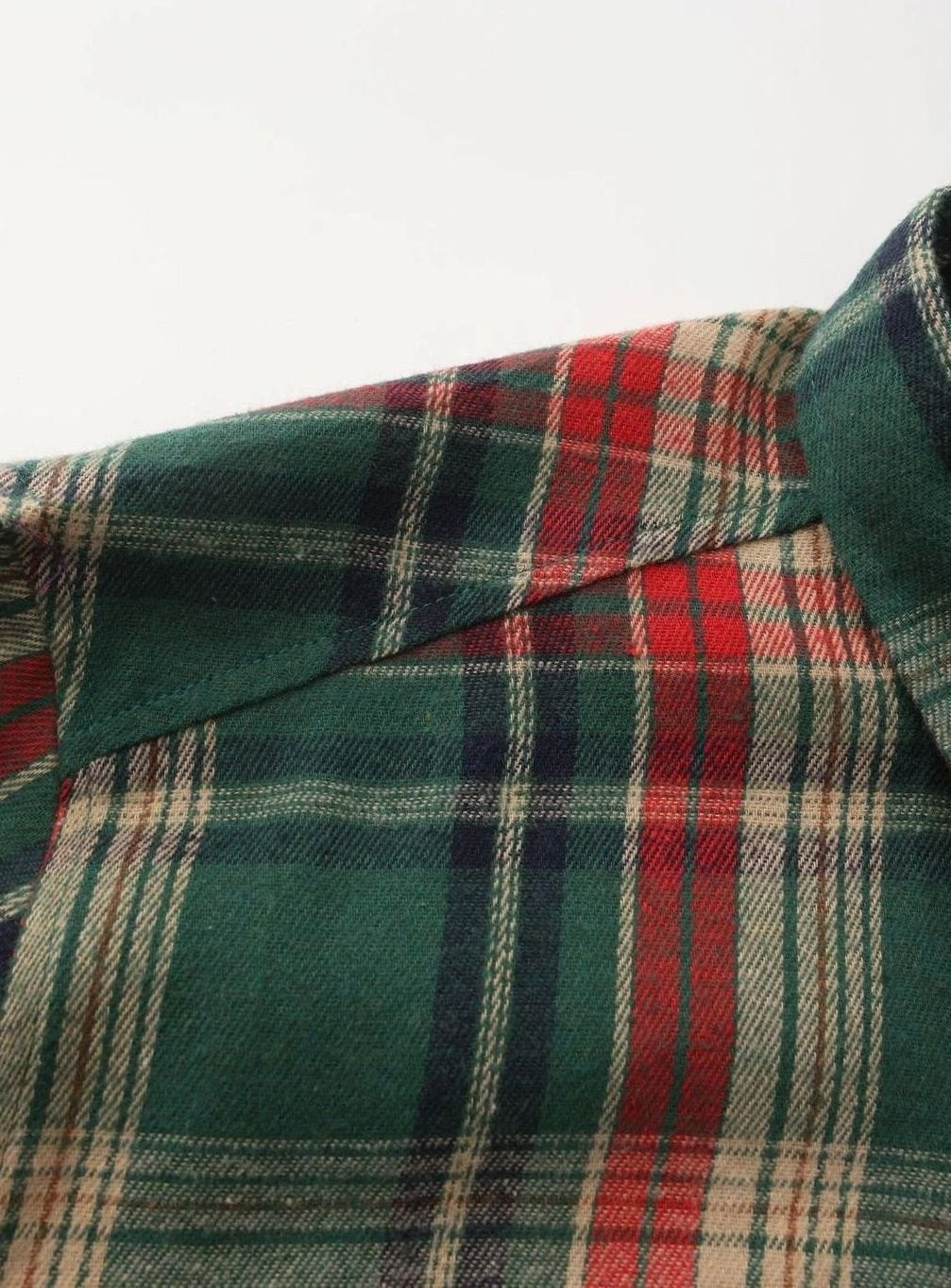 Detailed texture of green and red checked flannel shirt fabric