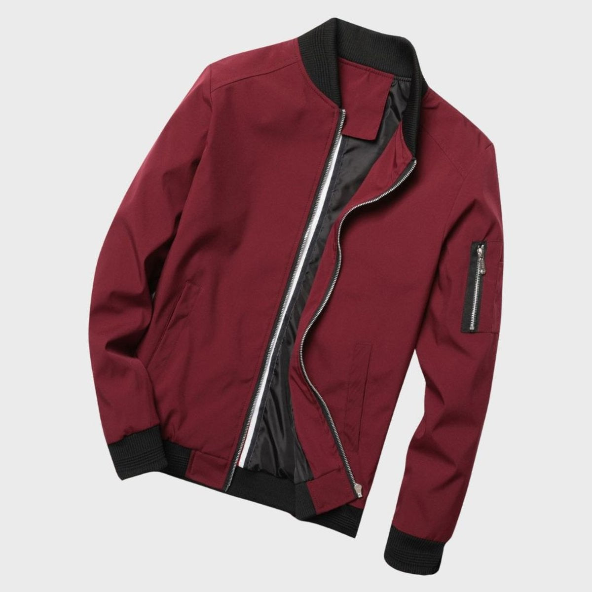 Burgundy bomber jacket laid flat showing ribbed trims and sleeve zip pocket