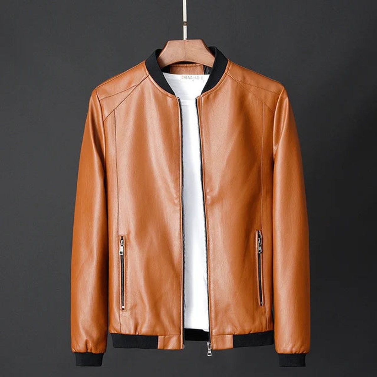 Tan faux leather zip-up bomber jacket displayed on wooden hanger