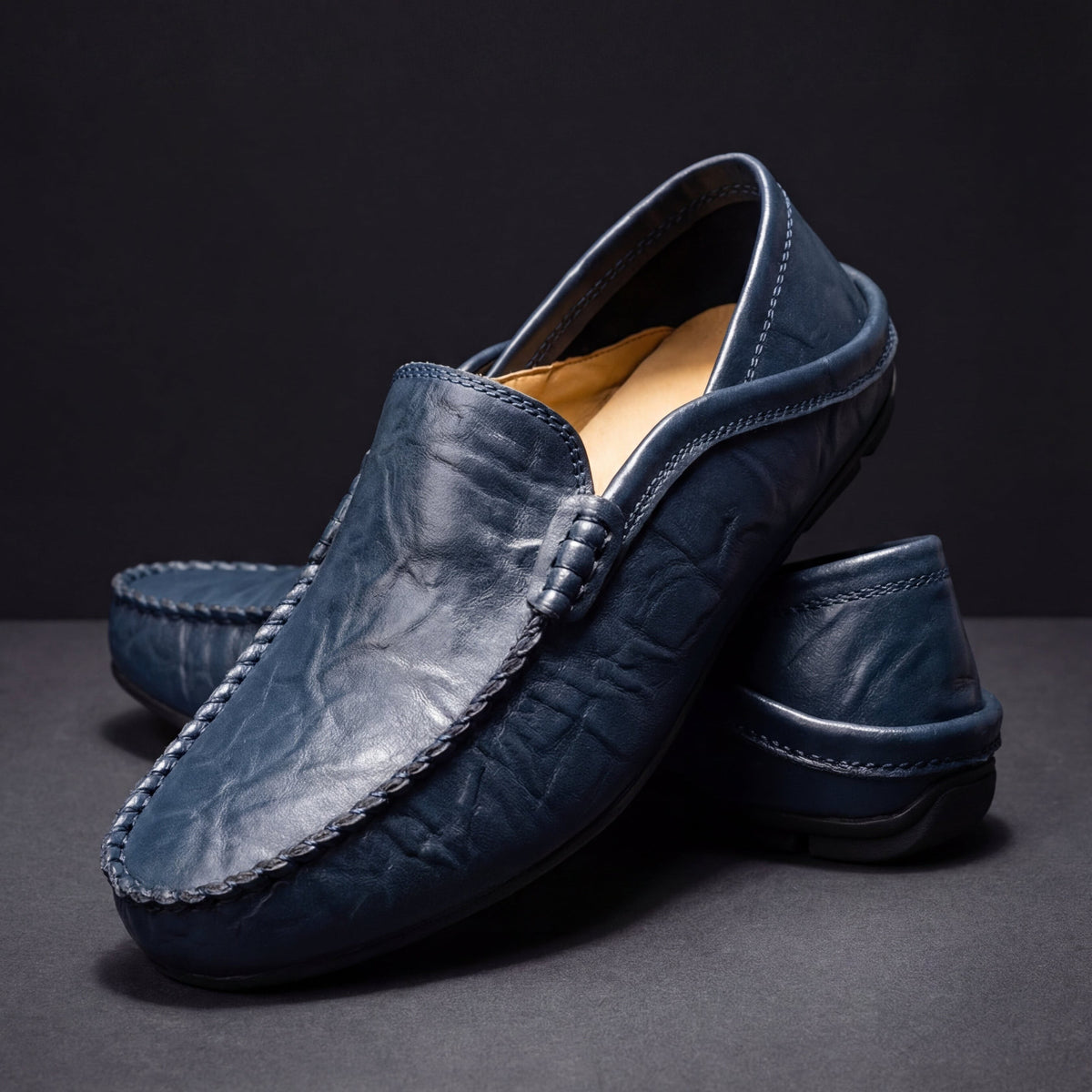 Navy leather slip-on moccasins with braided vamp strap and tonal stitching