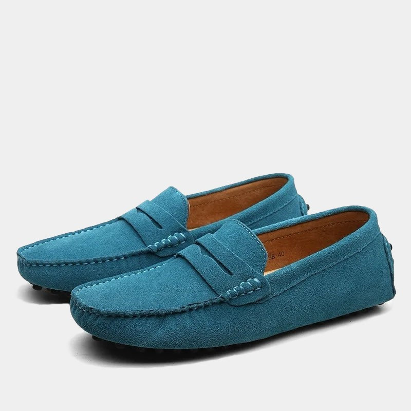 Teal blue suede slip-on loafers with tan leather insole and moccasin stitching