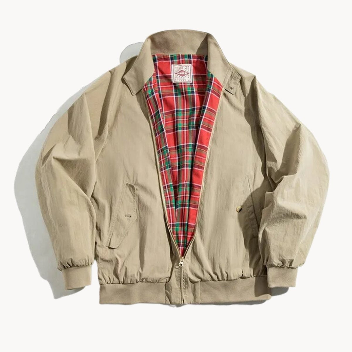 Beige Harrington bomber jacket with red tartan lining laid flat
