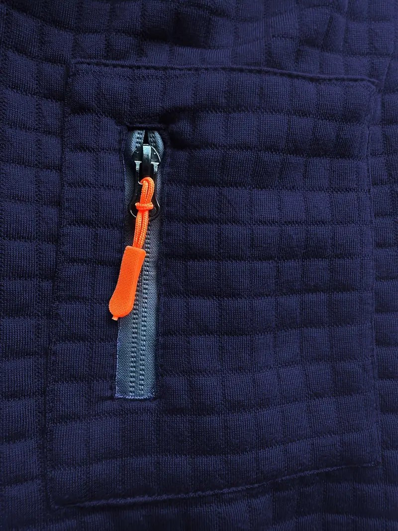 Close-up of sleeve zip pocket with orange pull tab on navy polo shirt
