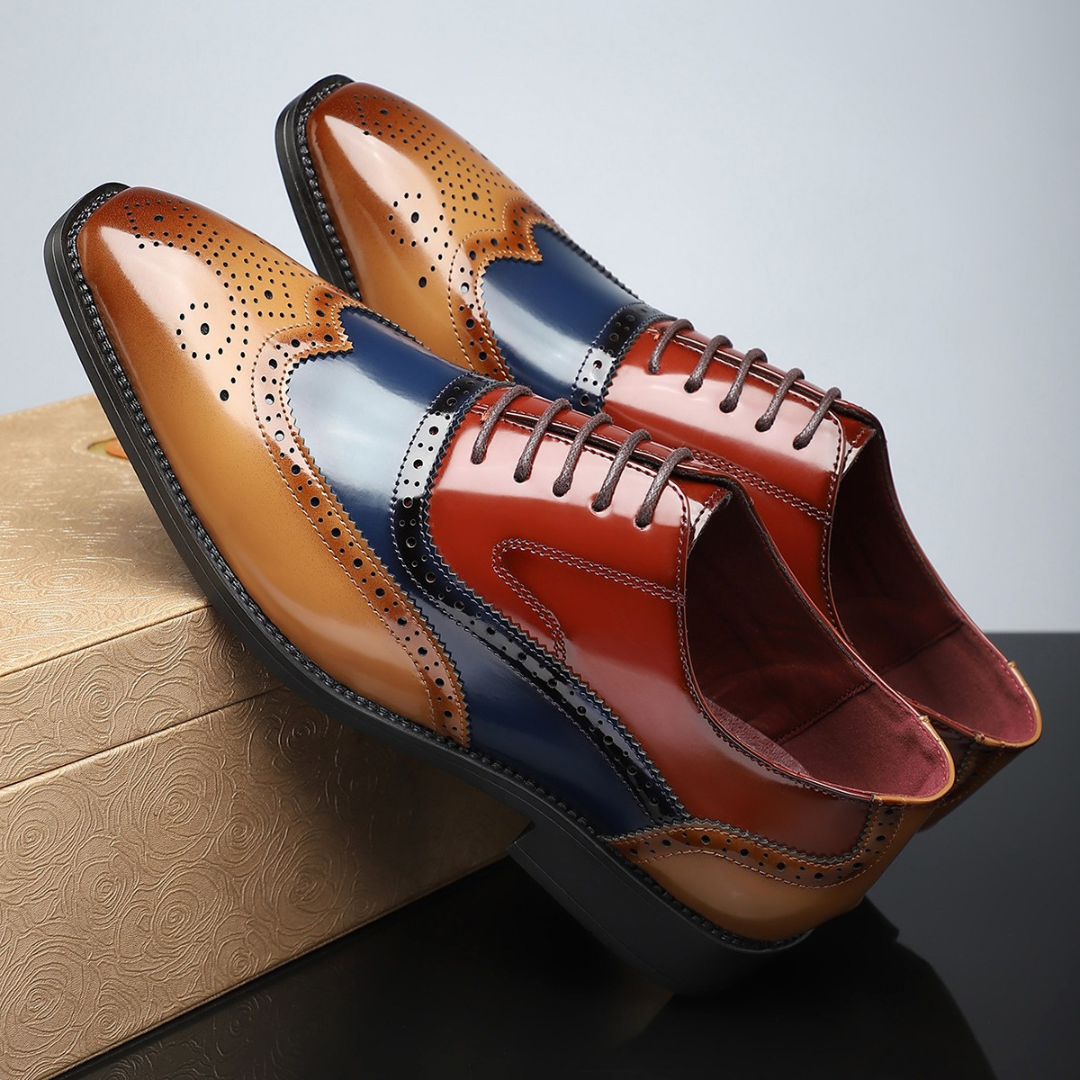 Pair of tan, red and navy leather brogues resting on gift box