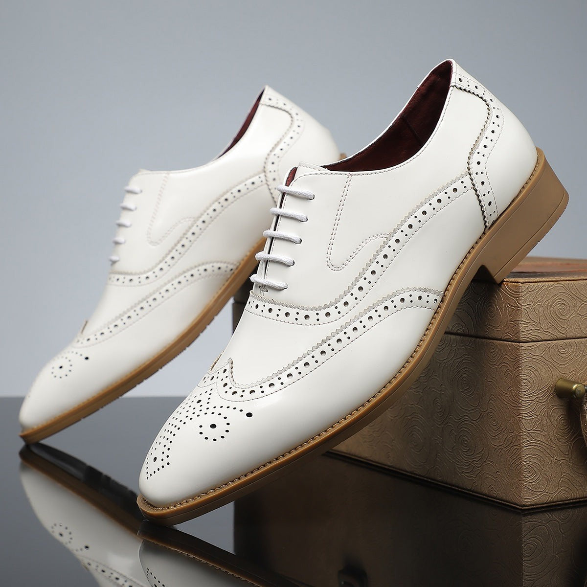 White leather brogues featuring tan sole and perforated wingtip detail
