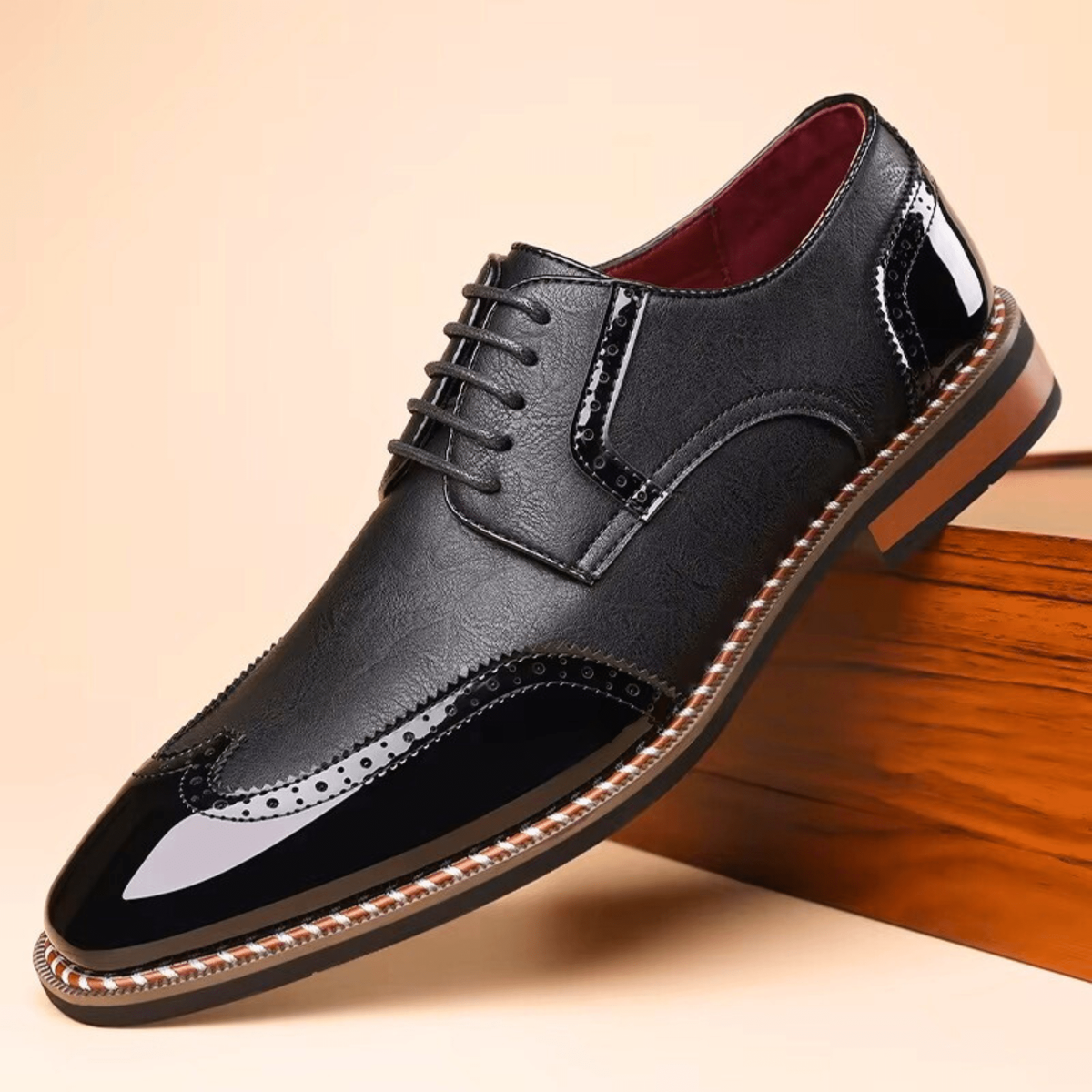 Black patent leather brogue shoe with textured upper and contrast stitched sole