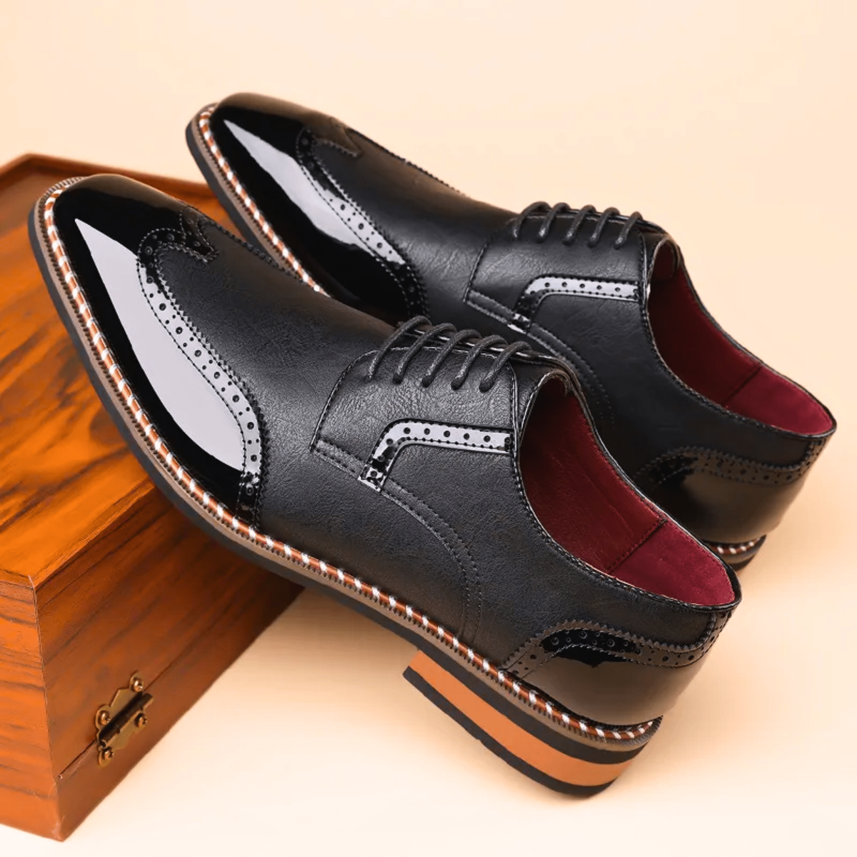 Pair of black patent leather brogue shoes with contrast stitched trim
