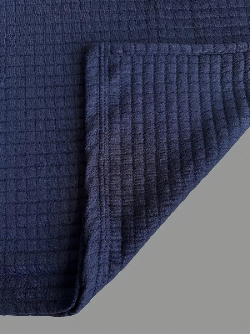 Close-up of navy waffle knit fabric and folded hem edge